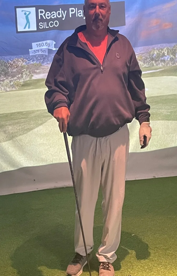 Mike “Swish” Piscitelli on the hitting mat after his hole in one, the simulator screen behind him reading 160.6y