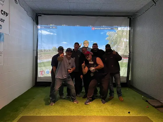 The winning team of the Super Bowl Shoot-Out in front of the simulator screen