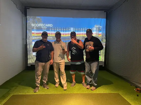 Four shoot-out champions in front of the simulator scorecard