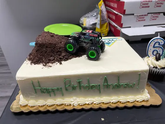 A birthday cake topped with a monster truck