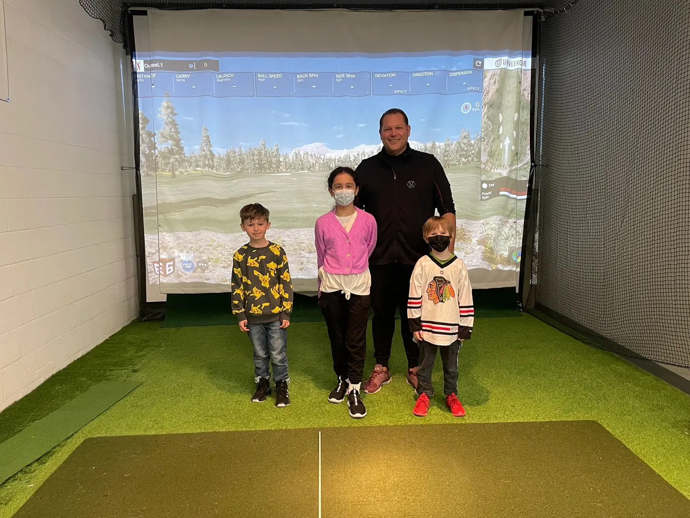 A coach with three young students in the simulator bay