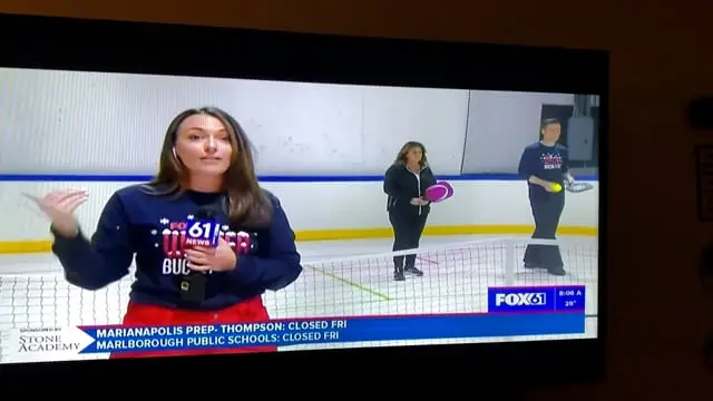 A FOX61 host on the court with pickleball paddles